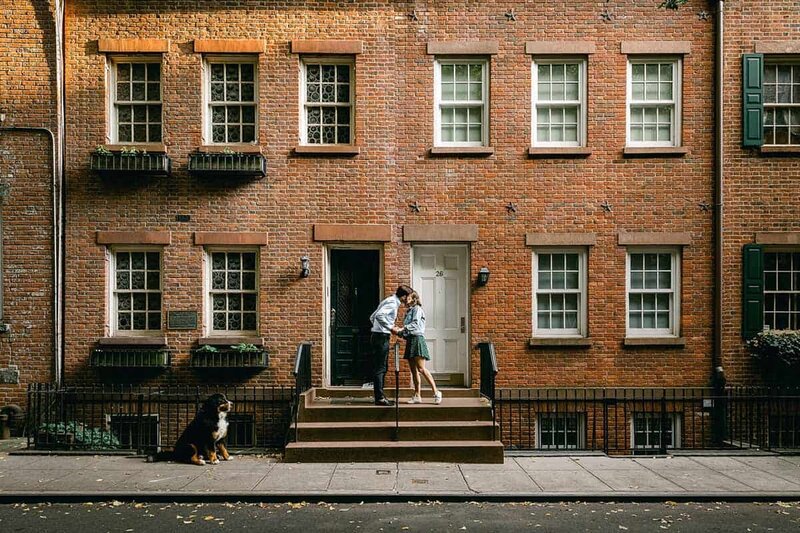 A couple kiss on the steps of a row house in the West Village