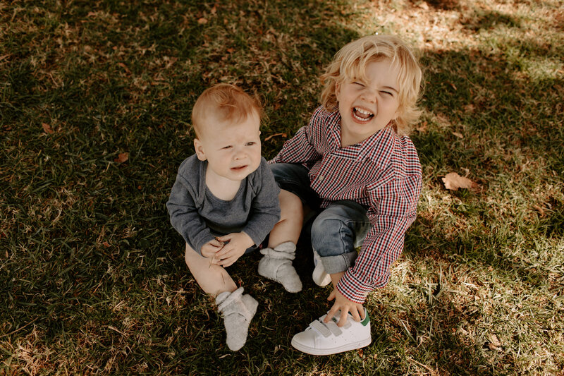 Two young brothers playing in the grass during a candid family photo session in Serra Madre, California. 
