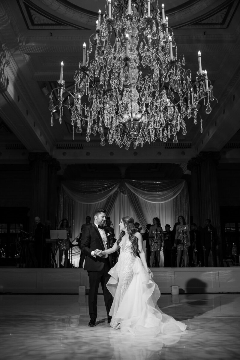 A side angle photo of a Down Town Club ballroom with tons of candles and white roses.