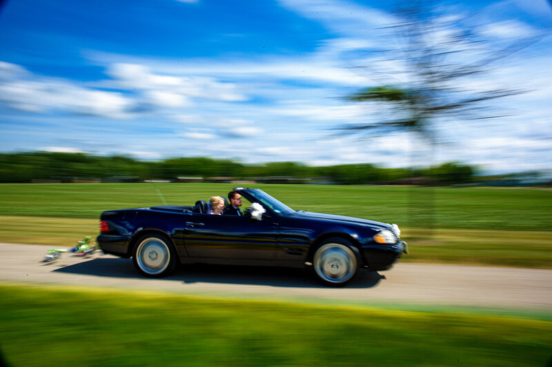 A wedding couple speeding off in a convertible after their wedding ceremony in Toledo Ohio 