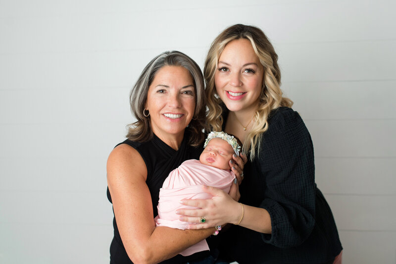 Generation portrait taken of grandma, mom and new baby girl.