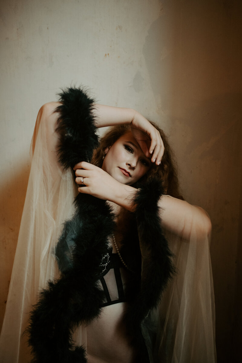 woman wearing sheer duster robe with black feathers and black lingerie