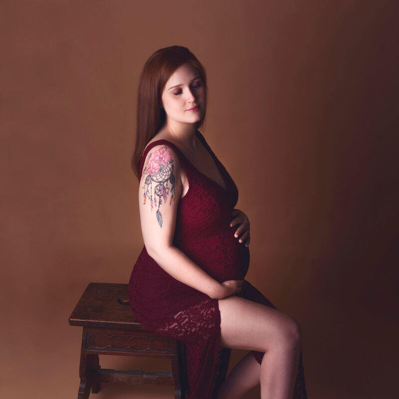 une femme enceinte assise avec une robe rouge