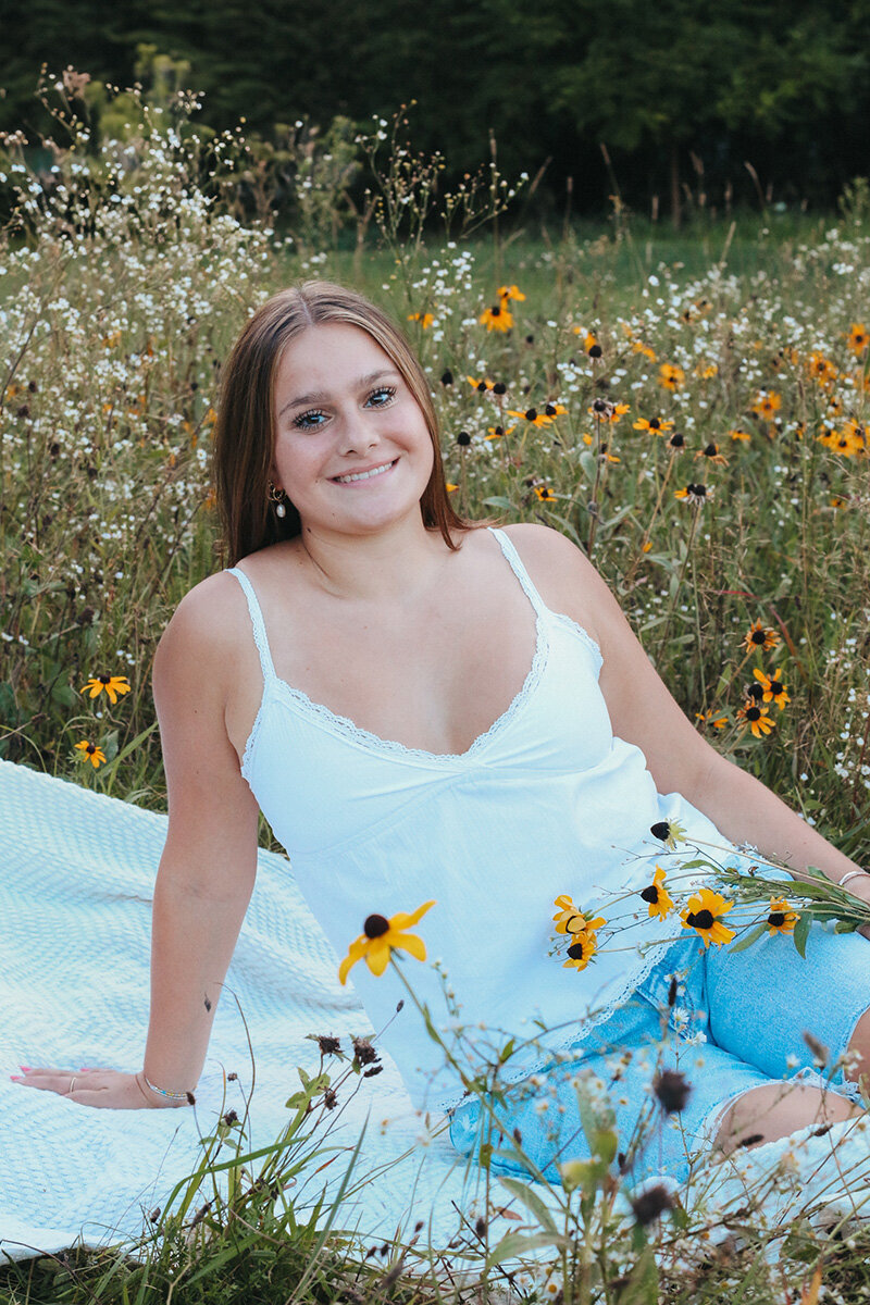 Young girl posing in a field of flowers for portrait photoshoot.
