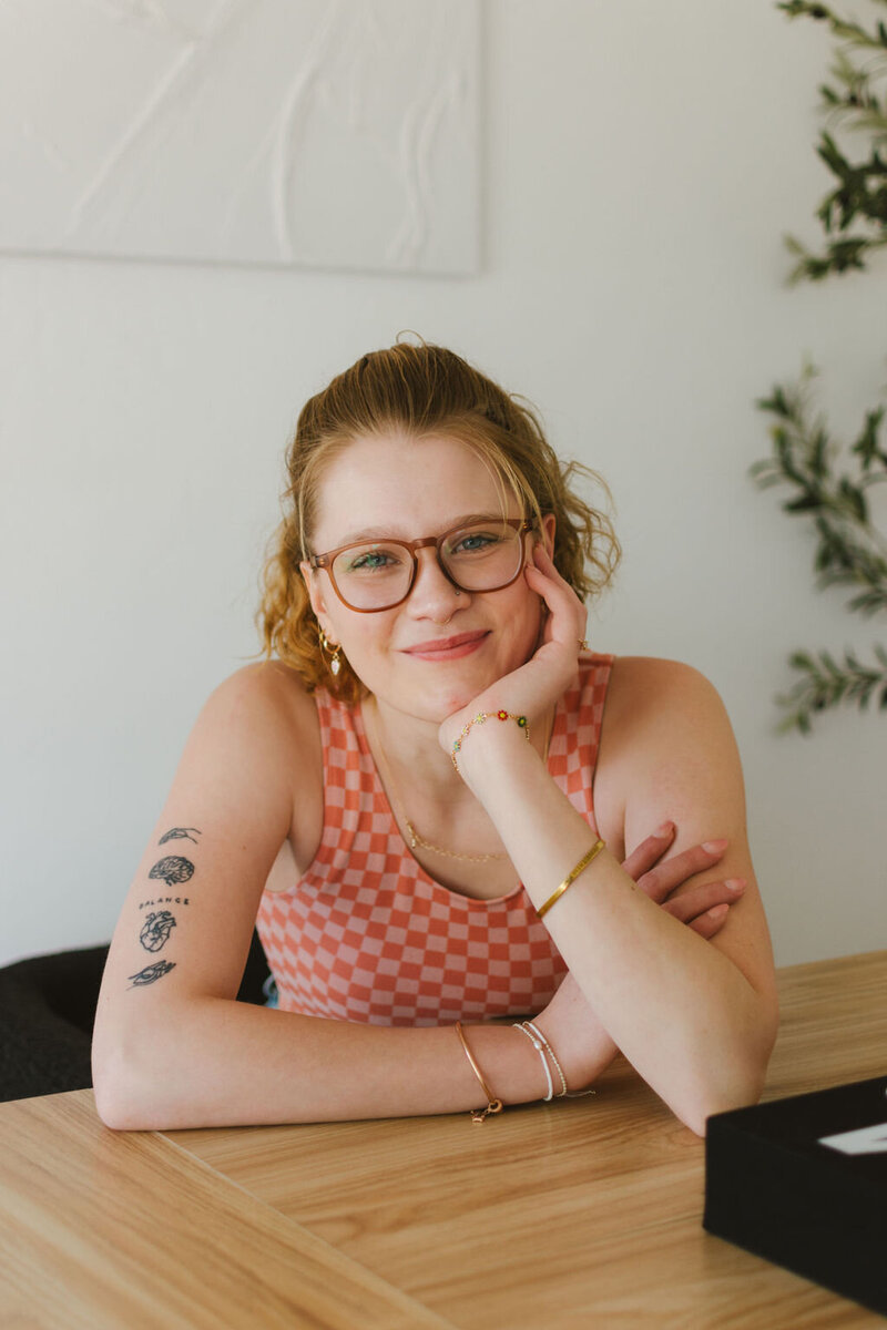 Lillian, creative virtual assistant for photographers and wedding pros, smiling at her desk during a relaxed branding session.