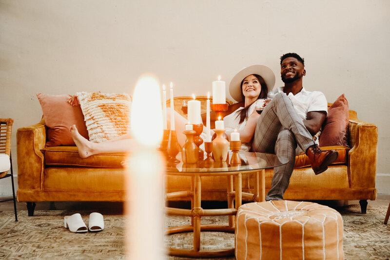 bride and groom sit on a leather couch