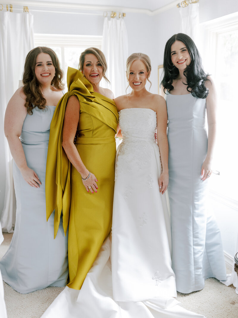 bride hugs her mom and sister on her wedding day