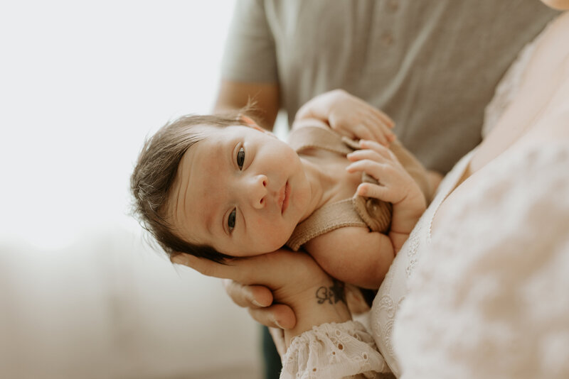 A woman holding a newborn baby in her hands.