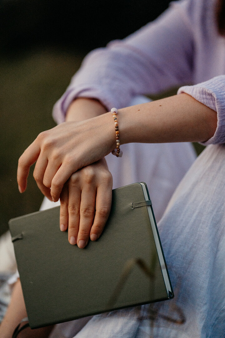 Nahaufnahme von Tessa Adrian, die in der Natur lacht, voller Freude und Gelassenheit.