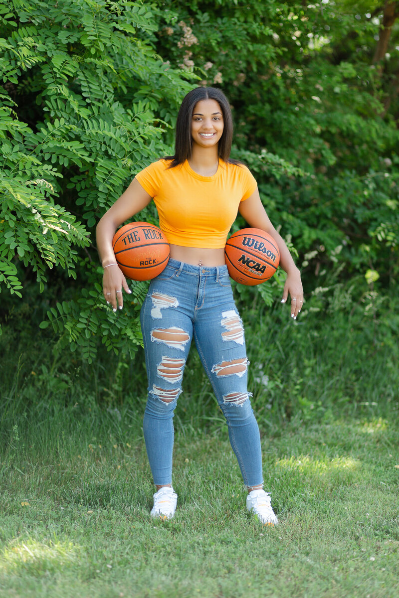 Female Basketball Player with basketballs under her arms