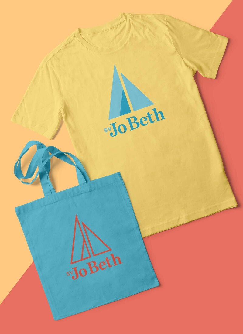 A brightly colored tote bag and t-shirt printed with different versions of the SV Jo Beth logo