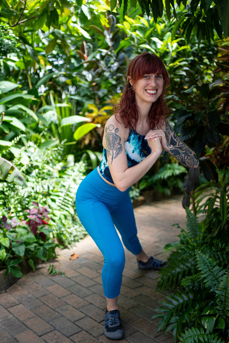 a woman in blue workout clothes does a bodyweight lateral lunge