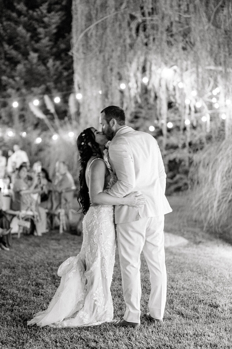 Tiffany Longeway Photography captures a magical nighttime kiss between the bride and groom at Beaulieu Garden in Napa Valley. The soft glow of string lights and the intimate garden setting create a romantic ambiance, perfect for couples seeking a luxurious and enchanting wedding experience in one of Napa Valley’s most picturesque venues.