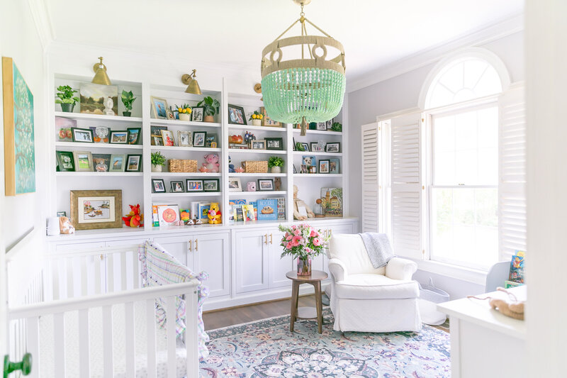 beautifully decorated baby nursery with a teal chandelier and build-in bookshelves in columbia, SC