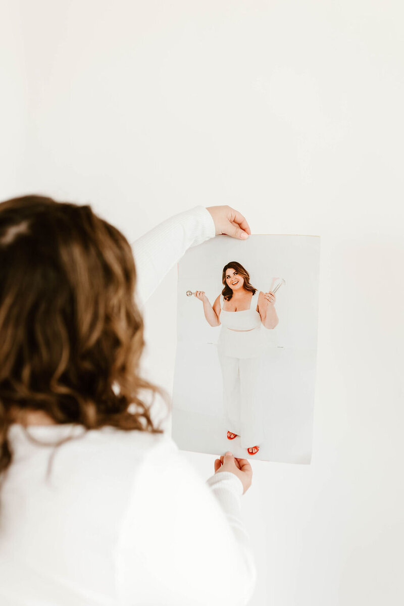 Macayla Hopper holding her custom skincare magazine featuring her esthetic services in Hartselle Alabama