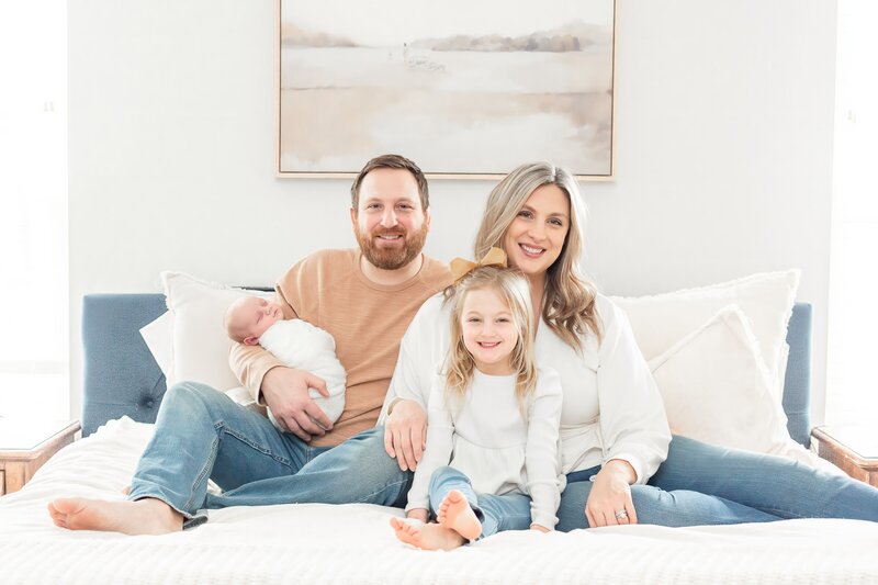 Mom with baby on bed during Ann Arbor Michigan Newborn Photographer Session
