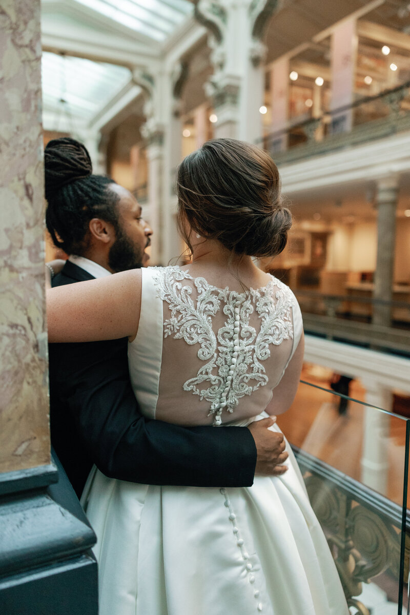 A couple stops for a warm embrace and candid portraits inside the National Portrait Gallery in Washington DC