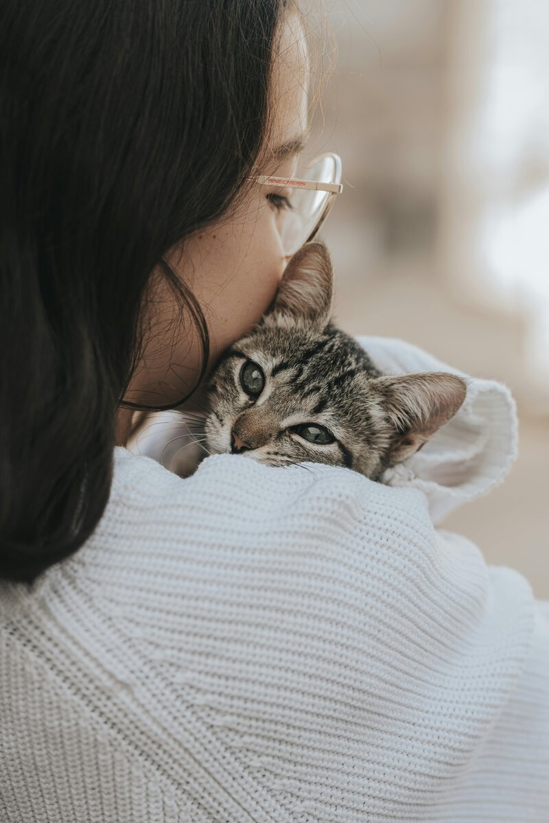 A woman hugging a cat, symbolizing the emotional support offered by the Pet Loss Support Group at MSU’s Veterinary Medical Center, providing a safe space for grieving pet owners