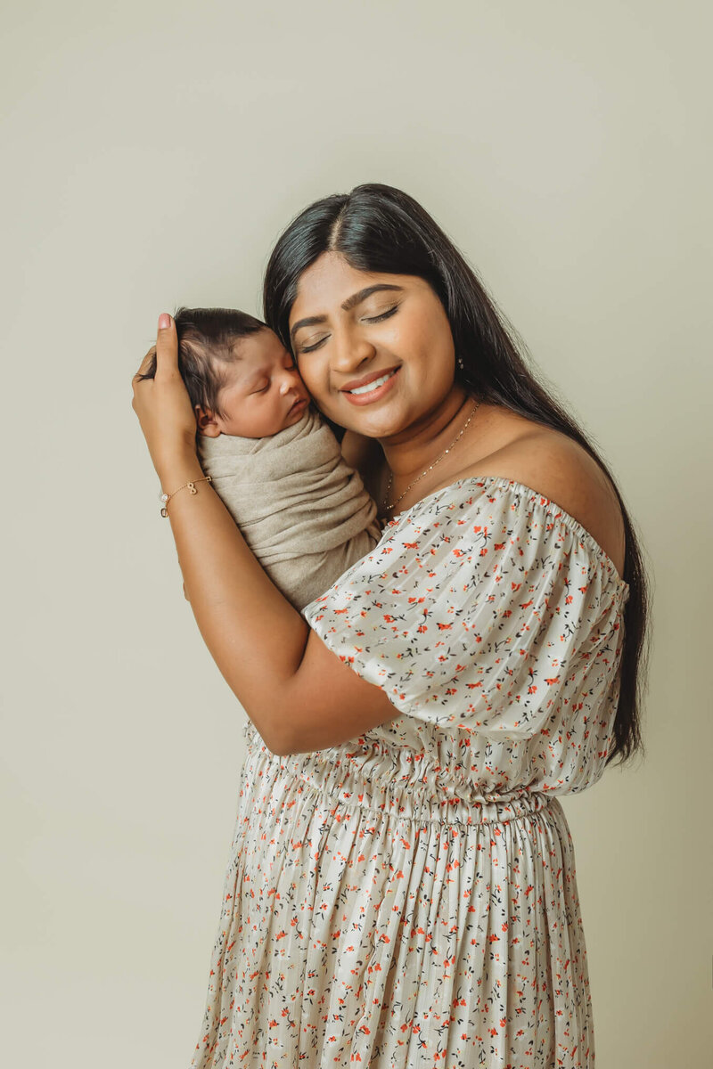 mom, dad and toddler daughter admiring newborn baby boy in studio newborn session