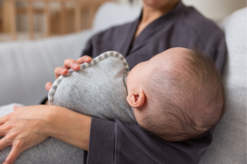 Woman in bed holding a newborn baby