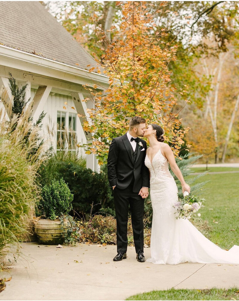 Bride and groom kissing outside venue entrance