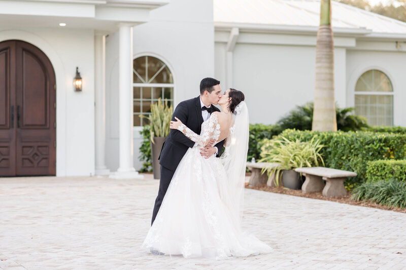 groom kisses bride outside of wedding chapel