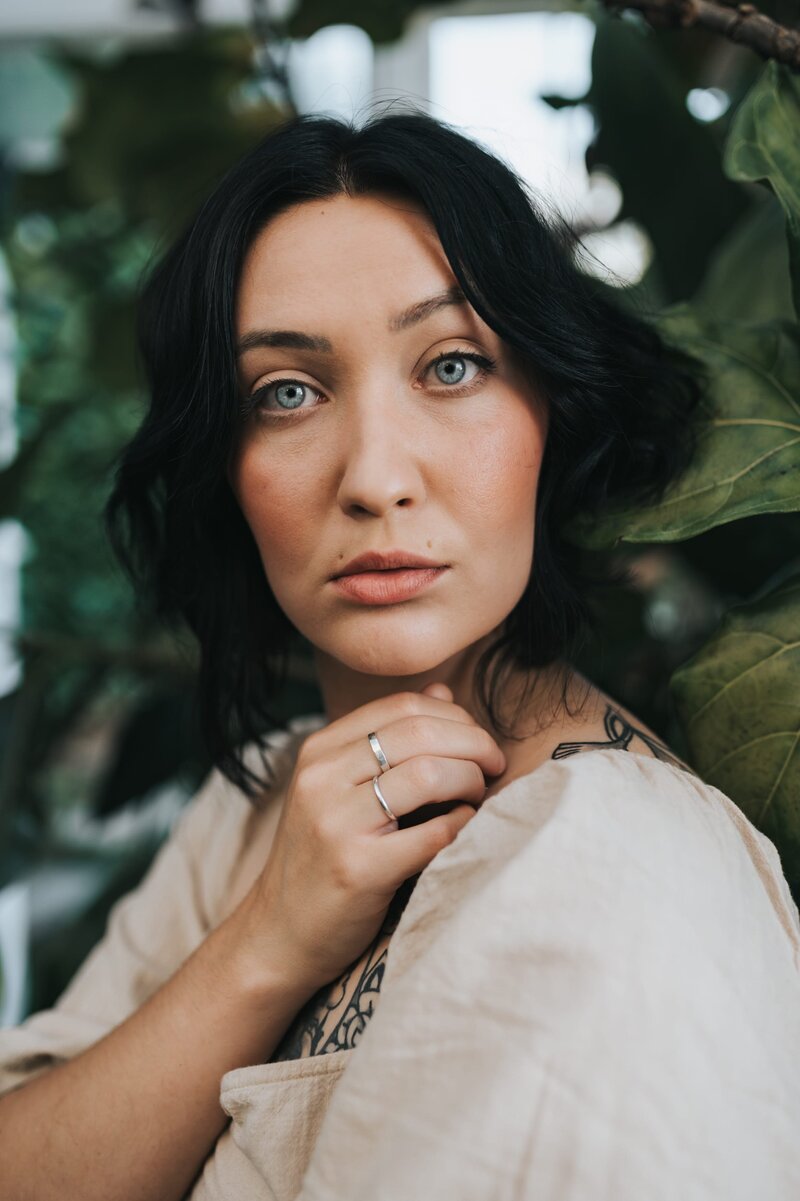 Woman with dark, short hair and light eyes looks at camera.