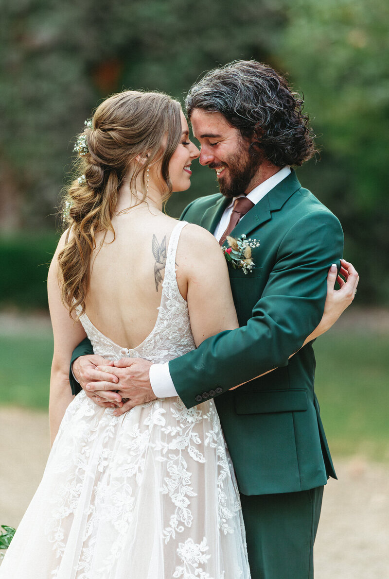 Bride and groom hugging during outdoor portraits in NWA Arkansas, shared in Joy and Light Photography wedding testimonials.