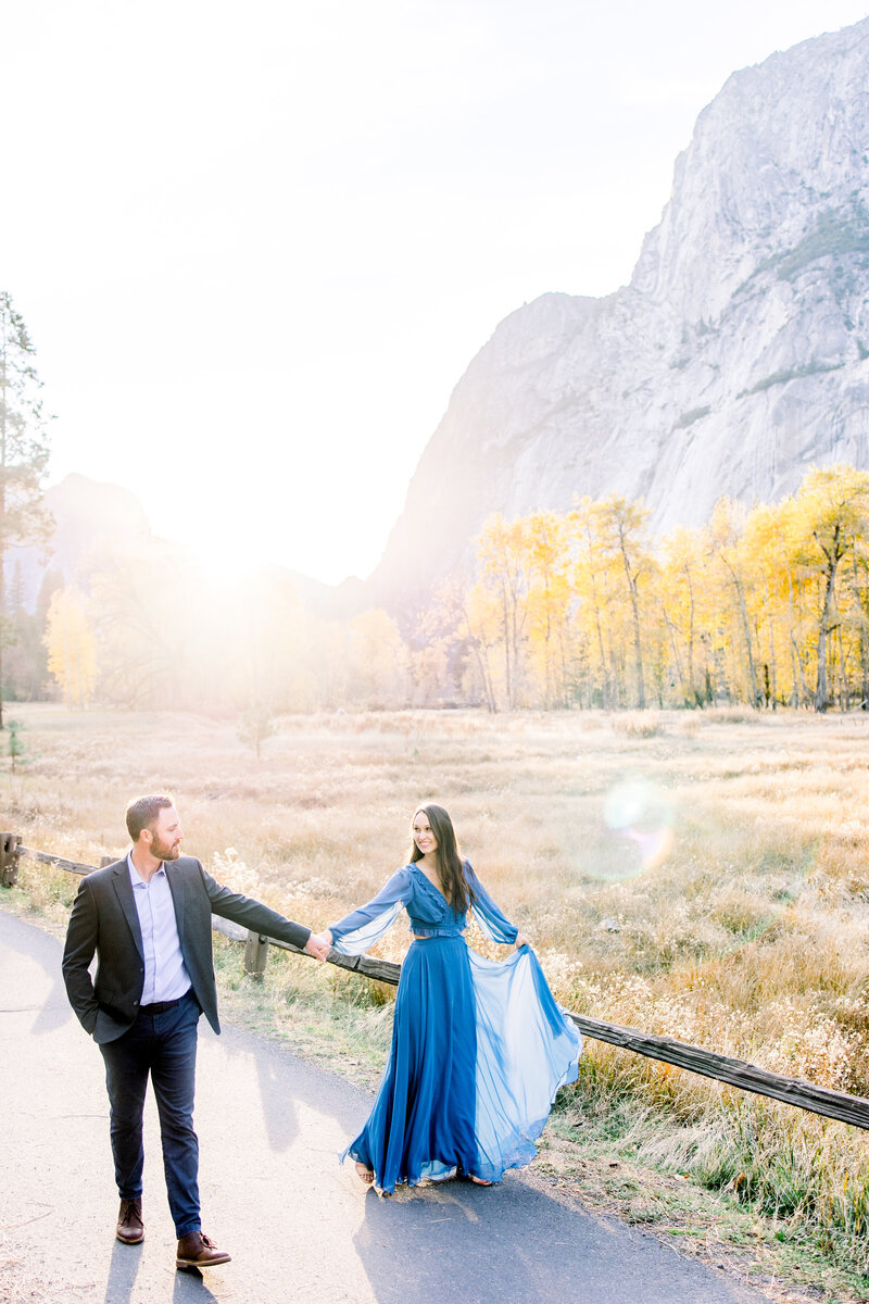 Engaged couple walks together on the Yosemite vallley flloor during their engagement photos