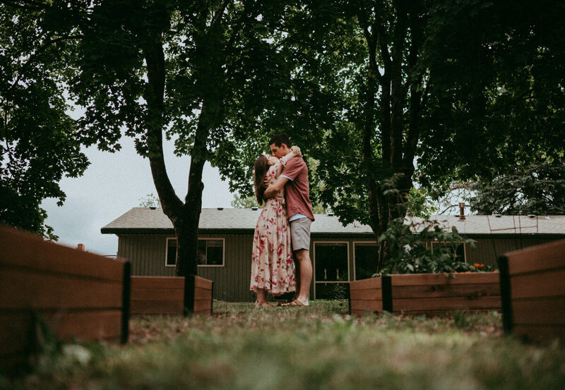 couple being photographed in a field of flowers by Portland maternity photographer