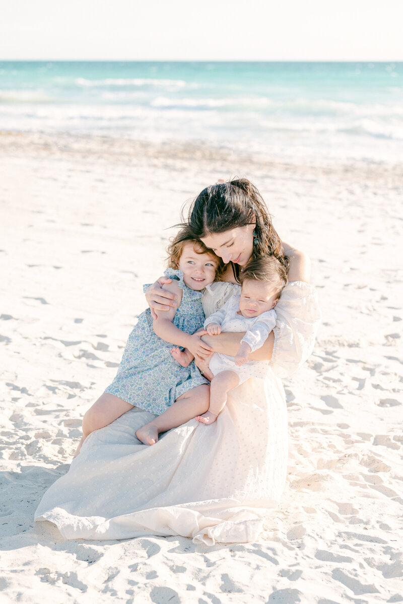 Mom, toddler and newborn on the beach