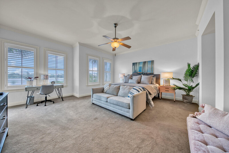 large master bedroom with king bed and couch