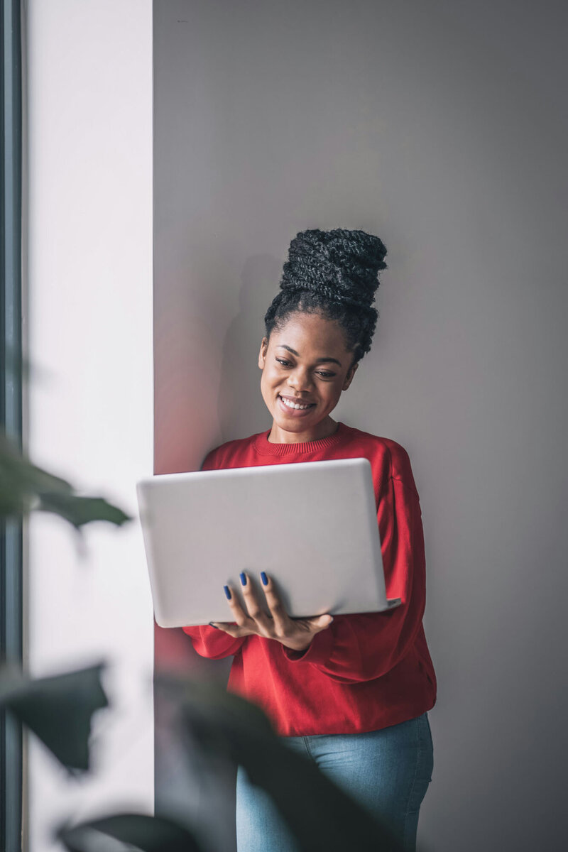 Woman happily watching at her laptop
