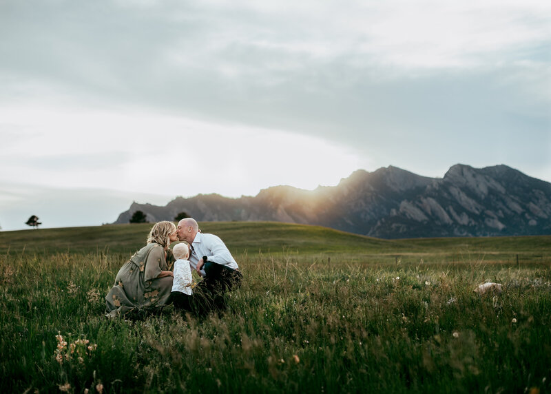 Family playing in a field at sunset in the summer in Boulder Colorado for family photos with Erin Jachimiak