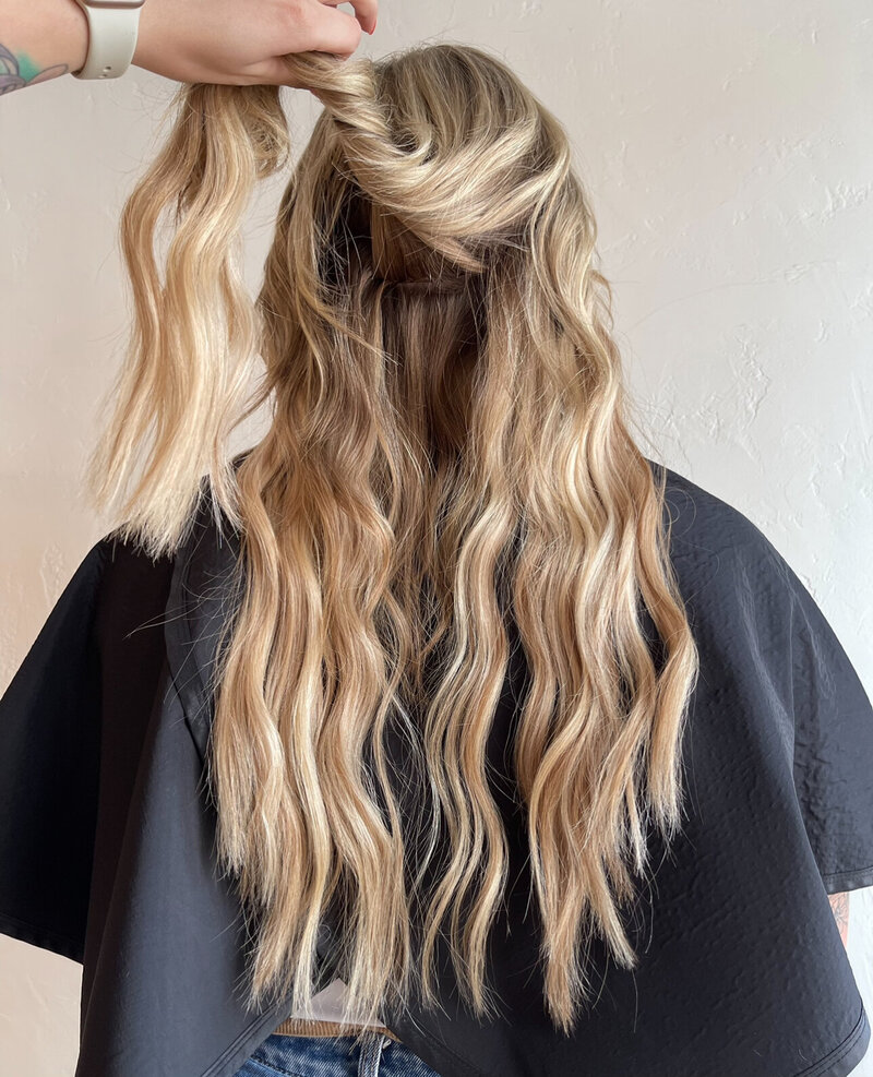 Showing how new extensions blend seamlessly into her hair for a natural look after her appointment at Anthology Salon near Appleton Wisconsin