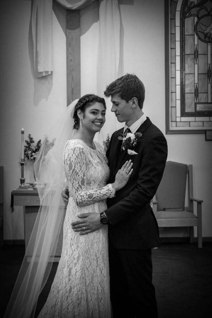 Wedding photo of Brent Austin and his wife Emma Austin, smiling joyfully on their wedding day at a church chapel, symbolizing love and connection shared in their personal journey with God, family, and wedding filmmaking.