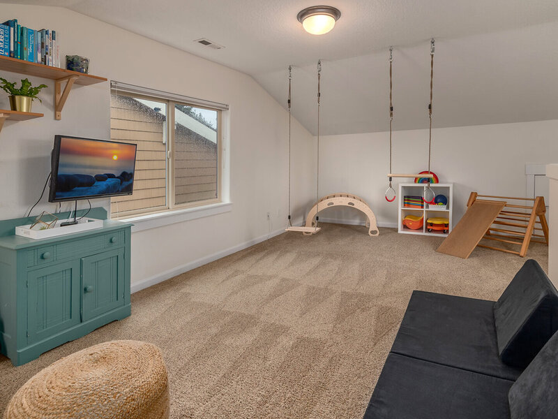 A large open playroom with beige carpets.