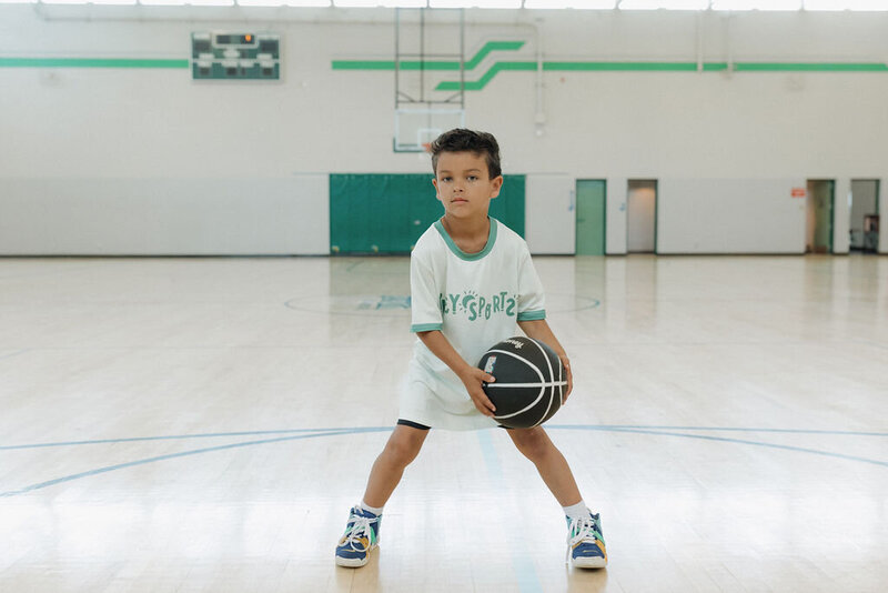 Kid playing basketball during a Pley Sports program in San Marcos, CA.