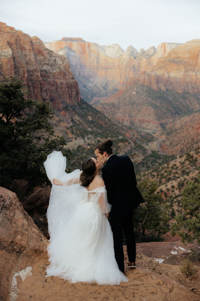 Couple exchanging vows with Zion’s red rock cliffs in the background.