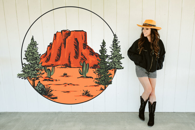 Annie Bee Photography portrait photographer posing next to her logo at sycamore venue in flagstaff.