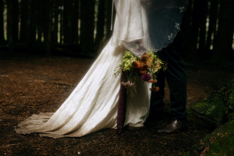 A bride wearing a vintage gown holding a bouquet made by Bloom Daddy. Elope Barrington Coast wedding at The Firs, Barrington Tops. Intimate and cinematic photography.