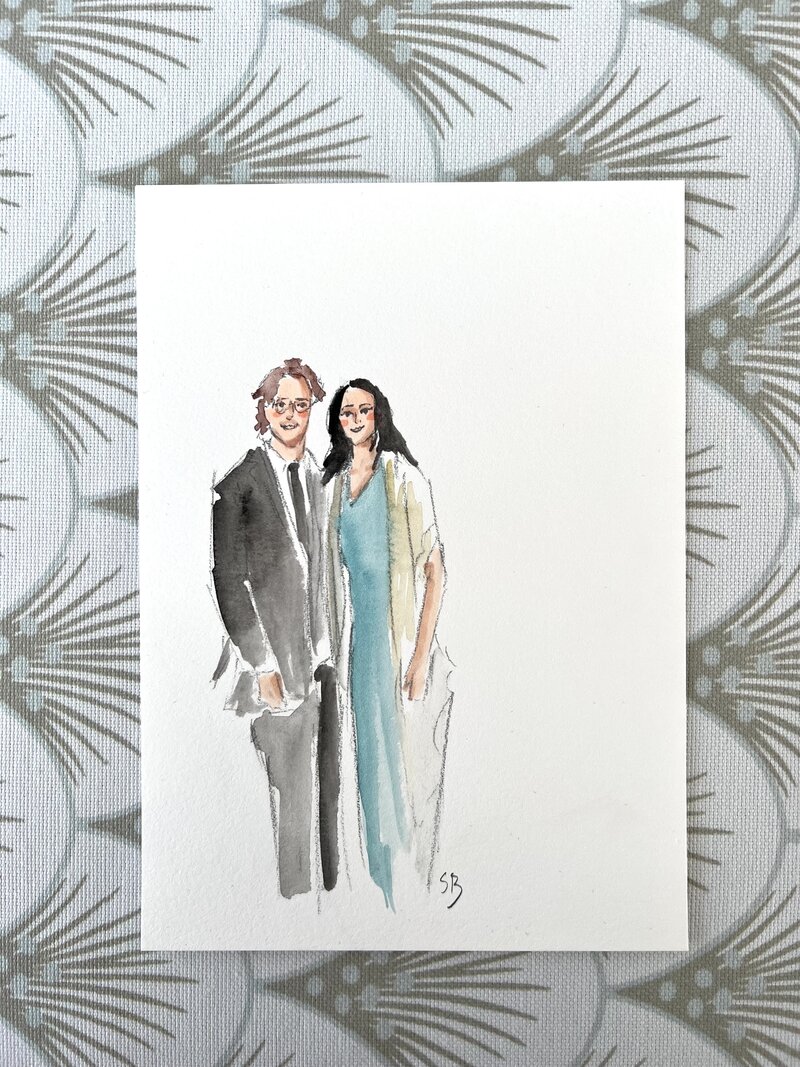 Watercolor portrait arranged with other wedding items