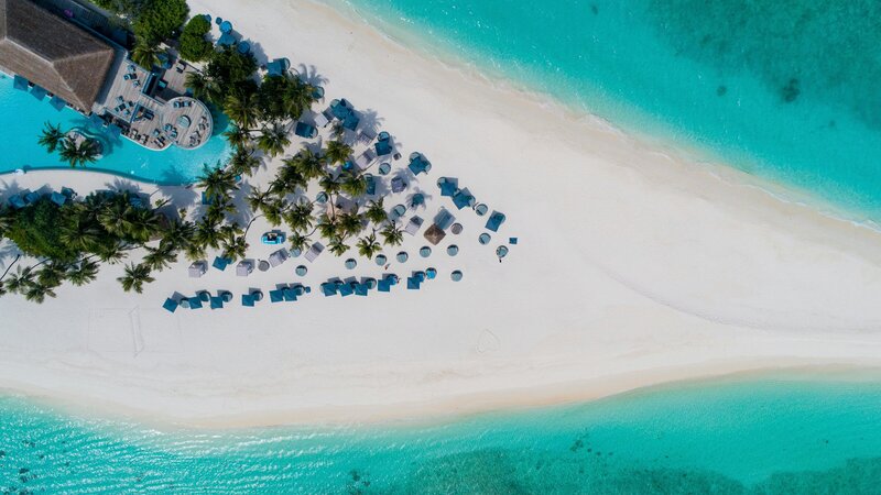 Aerial view of a luxury Caribbean resort on a white sandy beach.