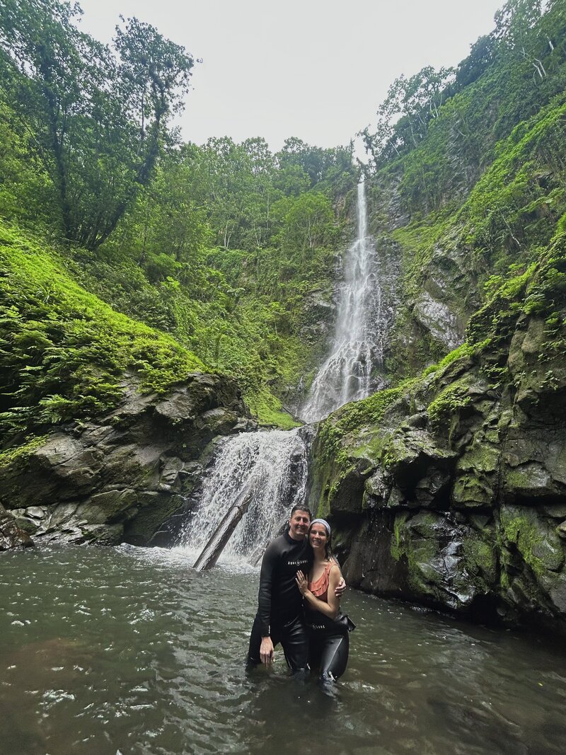 Couple posing in front of a waterfall on Cocos Island, Costa Rica