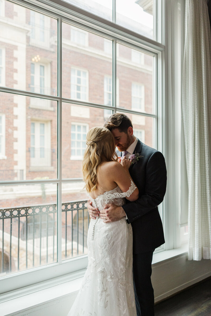 Intimate, natural light wedding photography of a couple sharing a private moment during their wedding portraits. Claire Katan Creative Omaha wedding photography.