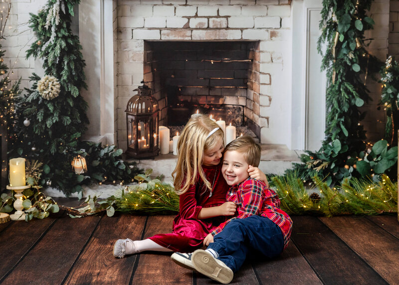 Holiday portrait of hugging siblings at Allison Reilly's Union County, NJ photo studio.