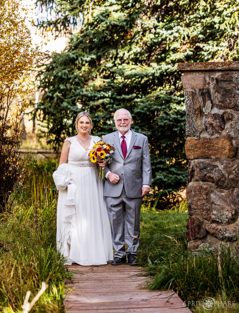 Bride and Her Dad Walk Down the Aisle at her Fall Wedding at Romantic Riversong Inn