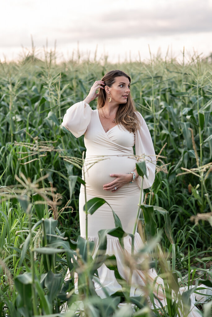 Expecting mom standing in cornfield