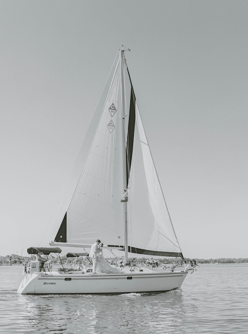 newport film photographer sailboat bride and groom in the harbor new england wedding photographer