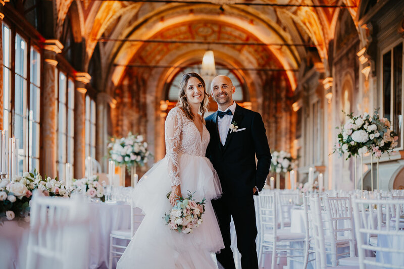 A newlywed couple embraced and smiling inside the splendid Villa Corsini in Mezzomonte.